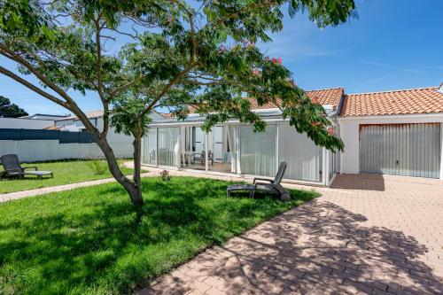 un parco con panchina e albero di Maison Avec Jardin 400m Du Centre a La Tranche-sur-Mer