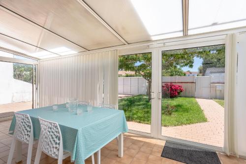 una sala da pranzo con tavolo e sedie blu di Maison Avec Jardin 400m Du Centre a La Tranche-sur-Mer