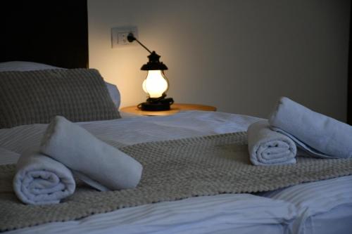 a bedroom with a bed with towels and a lamp at Apartment Abinkar in Tolmin