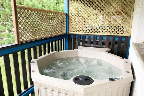 a hot tub on a balcony with a fence at Rathlin Apartment - 2 Bedroom with Hot Tub in Ballycastle