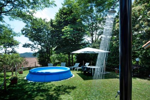 a backyard with a blue pool and a water fountain at Ai campi in Stella