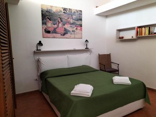 een slaapkamer met een groen bed met 2 handdoeken erop bij Green Space Apartment in Mondello