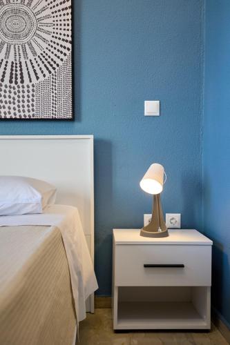 a nightstand with a lamp on it next to a bed at Chios Downtown Apartments in Chios