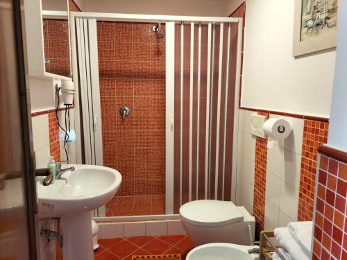 een badkamer met een wastafel, een toilet en een douche bij Green Space Apartment in Mondello