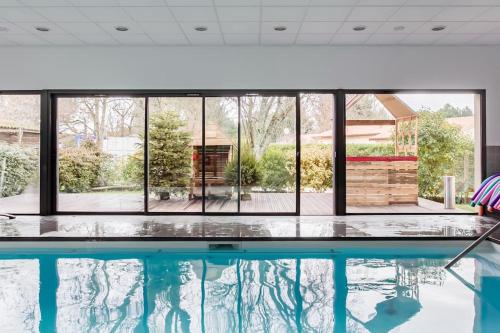 a swimming pool with a view of a large window at Gite Gauriaguet in Gauriaguet