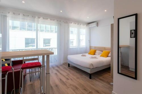 - une chambre avec un lit, une table et quelques fenêtres dans l'établissement ApartHotel Riviera - Balcon Lenval Sea View with AC Promenade des Anglais, à Nice