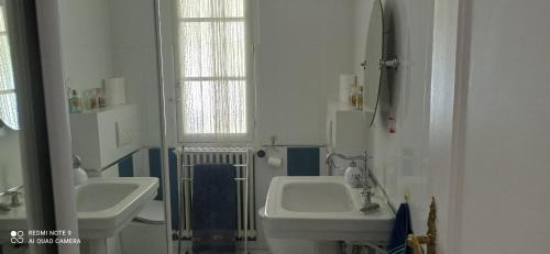 une salle de bain blanche avec deux lavabos et une fenêtre dans l'établissement Villa avec piscine à Antibes Côte d'Azur, à Antibes