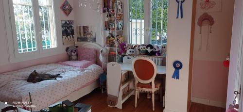 - une chambre avec un bureau et un lit avec un chat dans l'établissement Villa avec piscine à Antibes Côte d'Azur, à Antibes