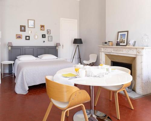 a bedroom with a bed and a table and chairs at Maison Dormoy in Marseille