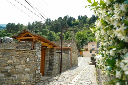 a stone house with a stone wall and a street at Gogo Moustache Guest House in Përmet