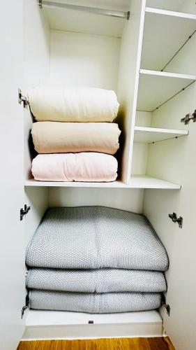 a closet with a stack of folded towels at National Stadium-Naadam Center-Tsengeldekh apartment in Ulaanbaatar