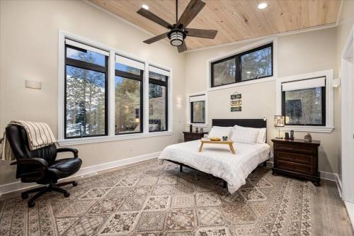 Un dormitorio con una cama y una silla y ventanas. en Norwegian Woods - Private Waterfront,66 Acres!, en Harrisville