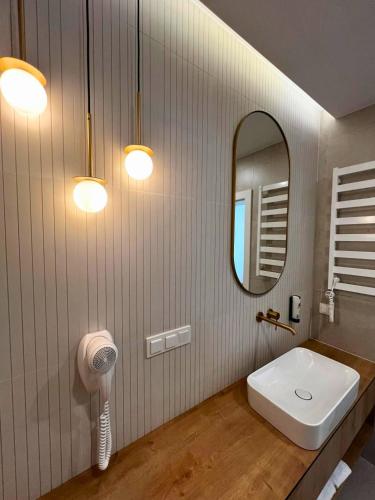 a bathroom with a sink and a mirror at Hotel & Restauracja Nad Sandelą in Lubawa