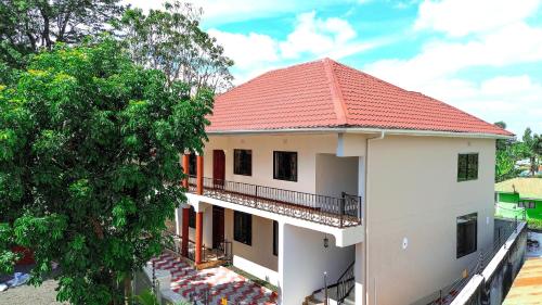 a white house with a red roof at Silent Inn Apartments in Arusha