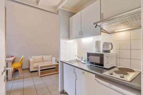 a kitchen with a sink and a microwave at Budget Flats Leuven in Leuven