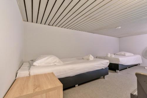 two twin beds in a room with a ceiling at Budget Flats Leuven in Leuven