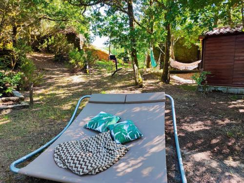 a bed with two pillows on it in a yard at Casa do Penedo in Castro Laboreiro