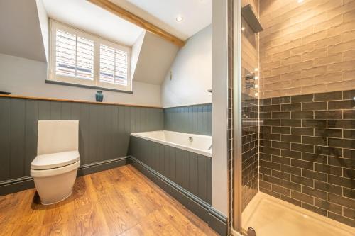 a bathroom with a toilet and a bath tub at Sherbet Cottage in South Creake