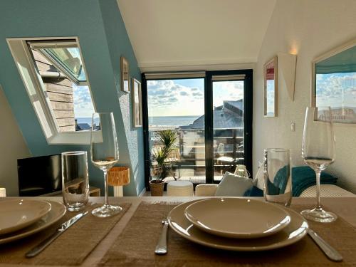 - une table avec des assiettes et des verres avec vue dans l'établissement Mini duplex vue imprenable, à Deauville