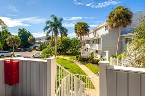 a house with a white fence and palm trees at Pool Access and Lanai Riverfront Welaka Condo! in Georgetown