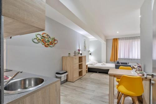 a kitchen and living room with a sink and a table at Budget Flats Leuven in Leuven