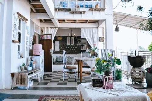 a living room with a table and chairs and a floor at Imah Seuri by Kaya Rooms in Tutugan