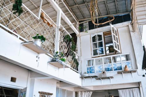 a white house with plants on the balcony at Imah Seuri by Kaya Rooms in Tutugan
