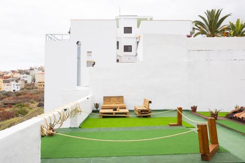 a balcony with chairs and a green lawn at Alojamientos Serendipity FM in Icod de los Vinos