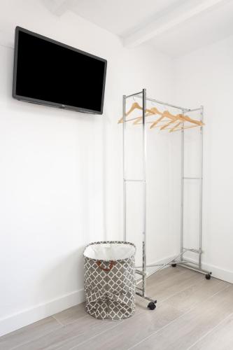 a room with a tv on a wall with a trash can at Alojamientos Serendipity FM in Icod de los Vinos