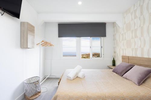 a bedroom with a large bed and a window at Alojamientos Serendipity FM in Icod de los Vinos