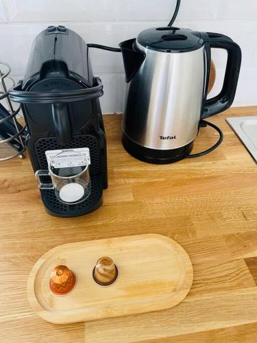 une planche à découper en bois à côté d'une cafetière sur un comptoir dans l'établissement Studio Charles de Gaulle II, à Castres