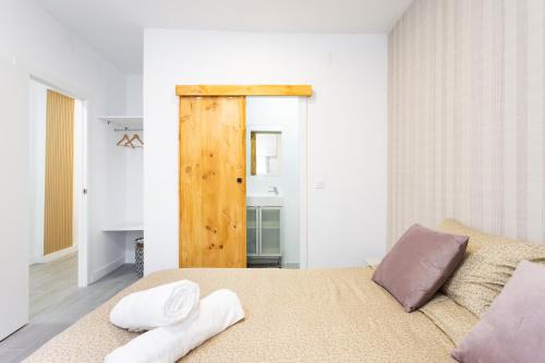 a bedroom with a bed and a wooden door at Alojamientos Serendipity FM in Icod de los Vinos