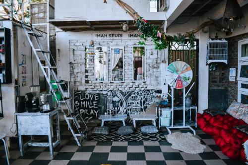 a room with a staircase and a wall with graffiti at Imah Seuri by Kaya Rooms in Tutugan