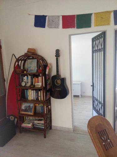 une pièce avec une étagère et une guitare au mur dans l'établissement Le Mazet, chambre chez l'habitant, à Cagnes-sur-Mer