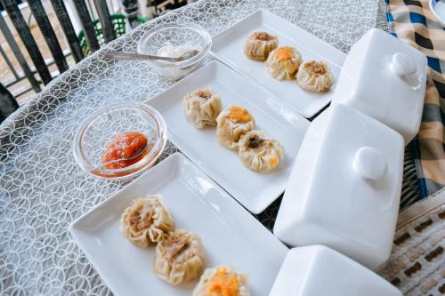four white plates of donuts on a table at Imah Seuri by Kaya Rooms in Tutugan