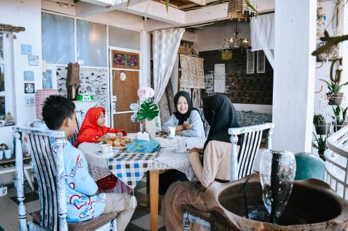 a group of people sitting at a table at Imah Seuri by Kaya Rooms in Tutugan