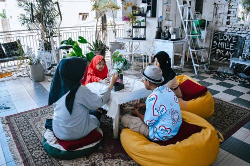 a group of people sitting around a table in bean bags at Imah Seuri by Kaya Rooms in Tutugan