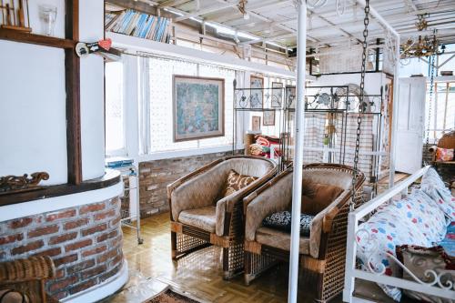 two chairs in a room with a brick wall at Imah Seuri by Kaya Rooms in Tutugan