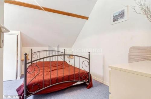 une chambre avec un lit en métal avec une couette rouge dans l'établissement Appartement familial spacieux et lumineux, à Barèges