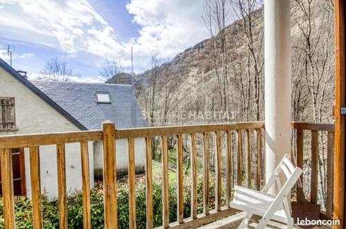 une chaise blanche assise sur une terrasse couverte avec une maison dans l'établissement Appartement familial spacieux et lumineux, à Barèges