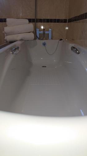 a bath tub in a bathroom with towels at Melroche House Doolin in Doolin