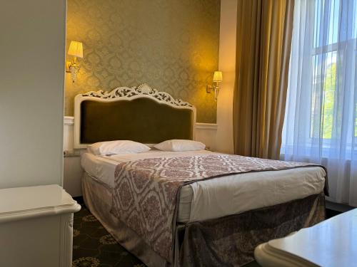 a hotel room with a bed and a window at Royal Grand Hotel in Kyiv