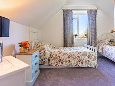 a bedroom with a bed and a dresser and a window at mulberry house in Flordon