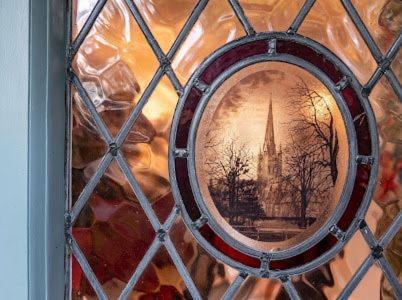 a stained glass window with a picture of a church at mulberry house in Flordon