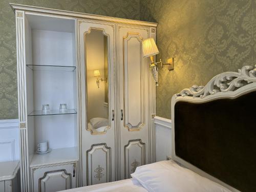 a bedroom with a bed and a cabinet with a mirror at Royal Grand Hotel in Kyiv