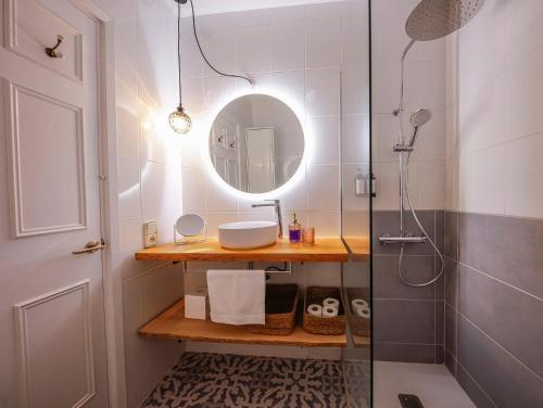a bathroom with a shower with a sink and a mirror at Apartament Cargol in Es Mercadal