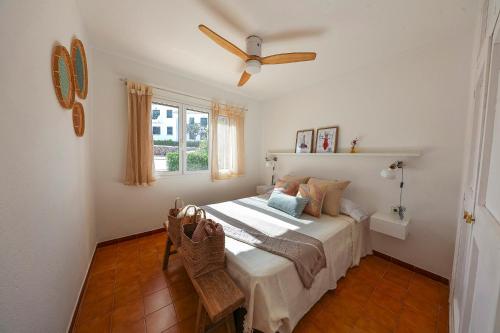 a bedroom with a bed and a ceiling fan at Apartament Cargol in Es Mercadal