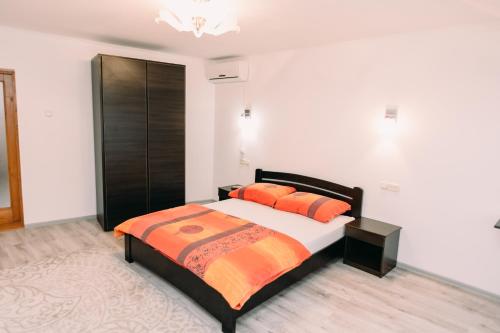Apartments in Uzhgorod في أوجهورود: غرفة نوم مع سرير مع وسائد برتقالية