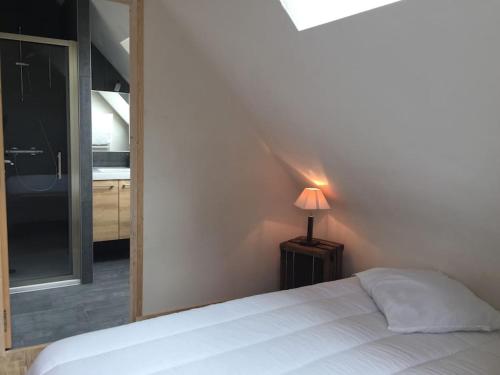 une chambre avec un lit blanc et une lampe dans l'établissement Petite maison Piscine et Vue sur la mer, à Carnac