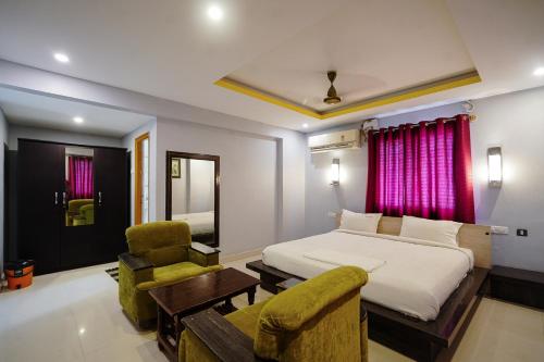 a bedroom with a bed and a couch and a chair at Hotel Sai Golden Rooms Deluxe in Tirupati